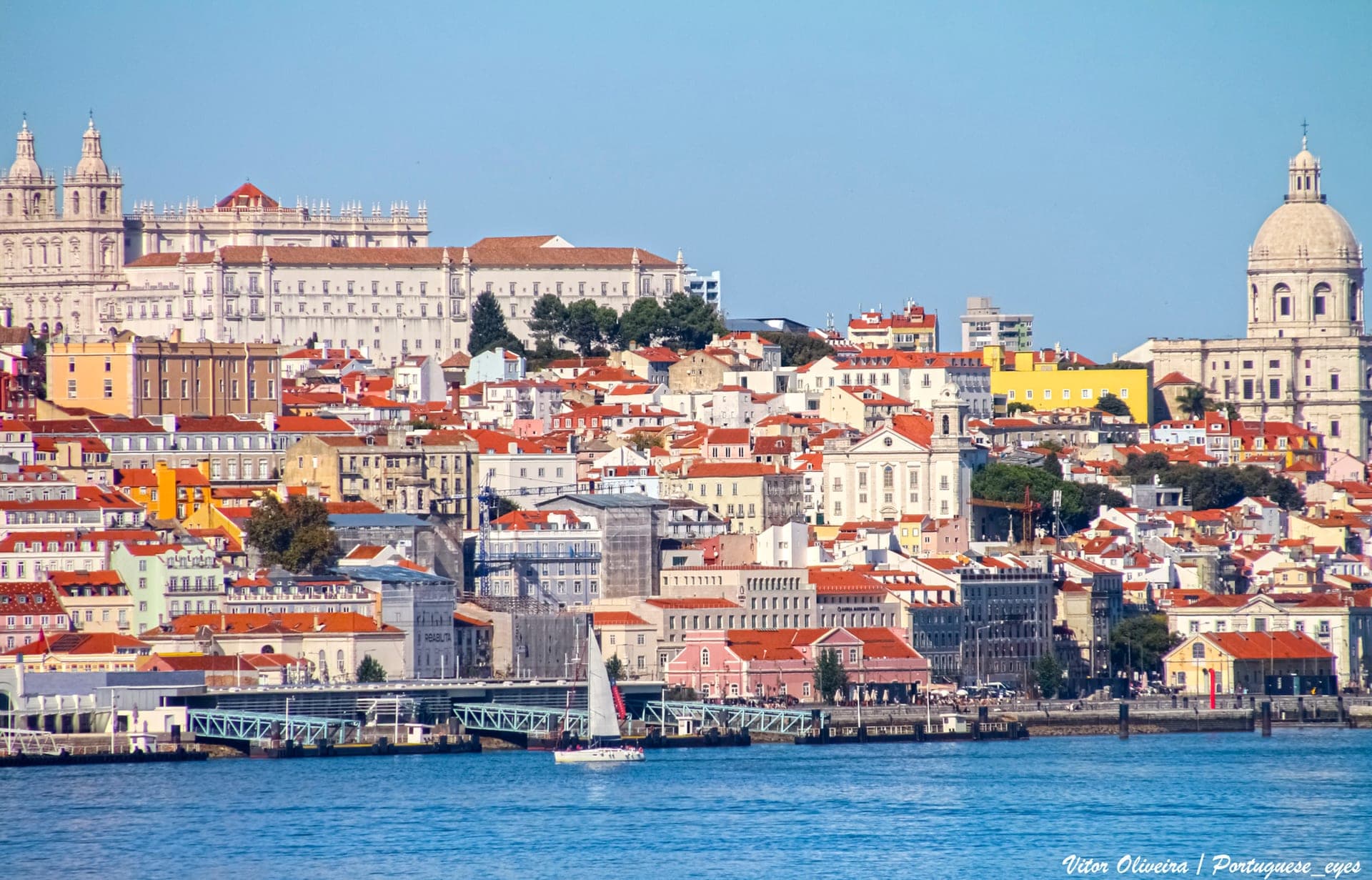 Lisbon's white and terracotta rooftops tumbling down the hillside to the Tagus, with the dome of the National Pantheon above them