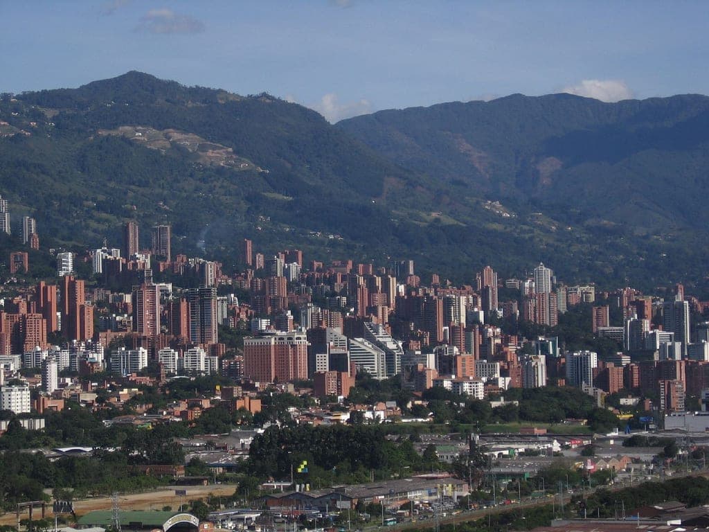Medellín's high-rise blocks packed across the valley floor, green Andean slopes rising on every side